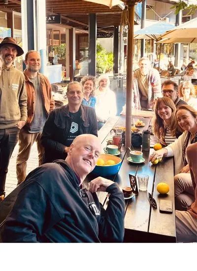 People gathered around a table at a relaxed Remix coffee morning in Byron.