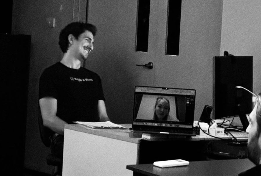 A local presenter stands beside a laptop showing a streamed OpenAI speaker at The Remix in Byron.